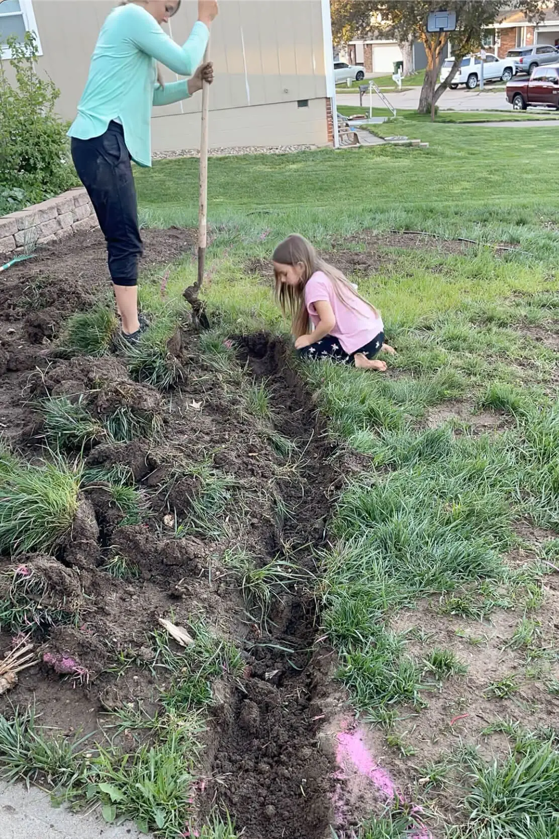 Shoveling dirt out of a trench.